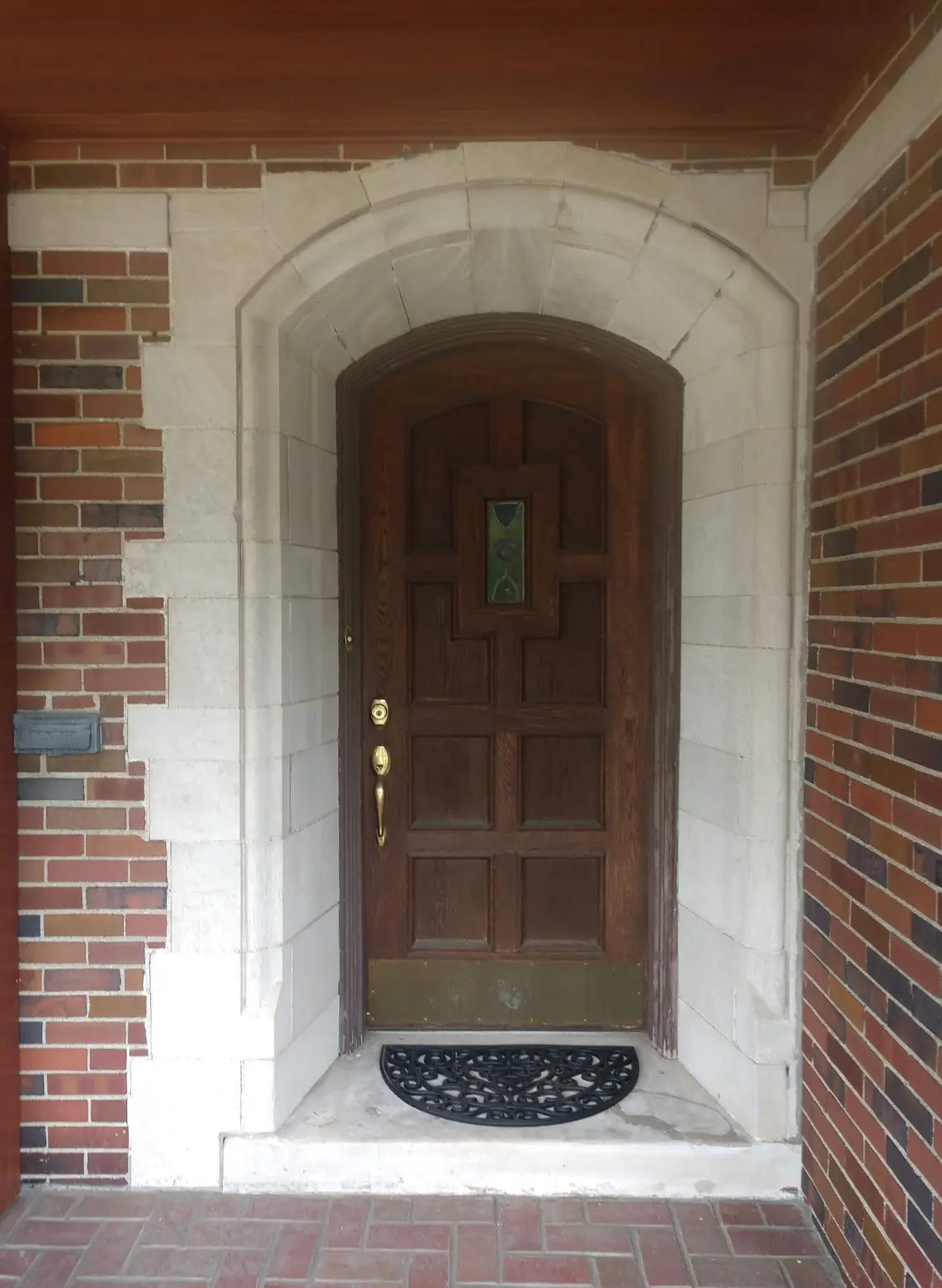 Paneled door under a stone arch before: dark and dull