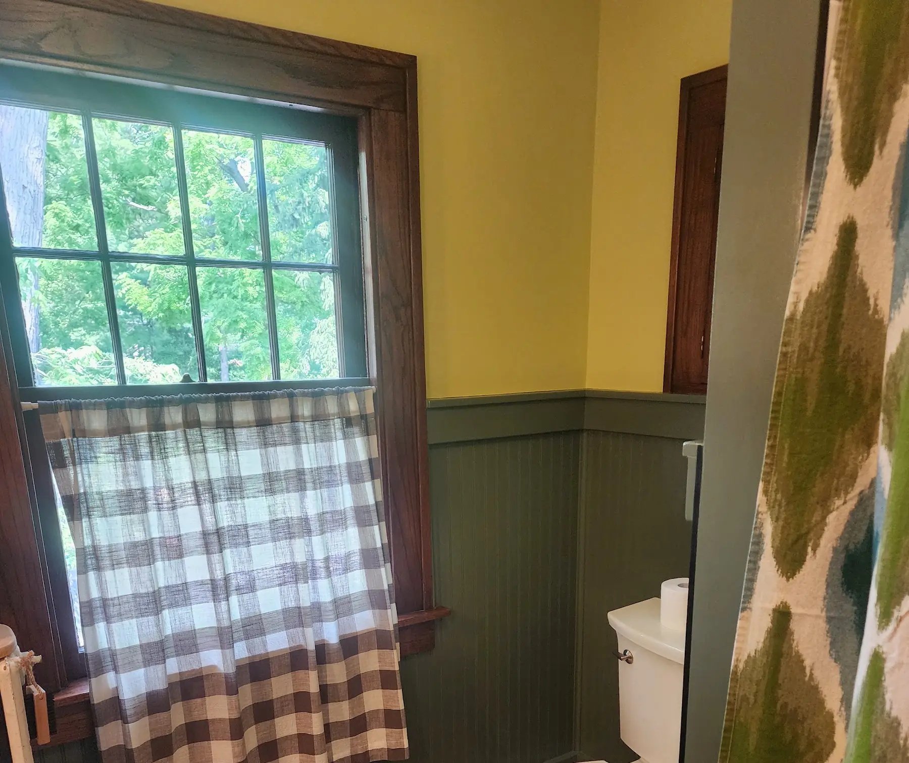 The same window finished, with a plaid cafe curtain over green beadboard