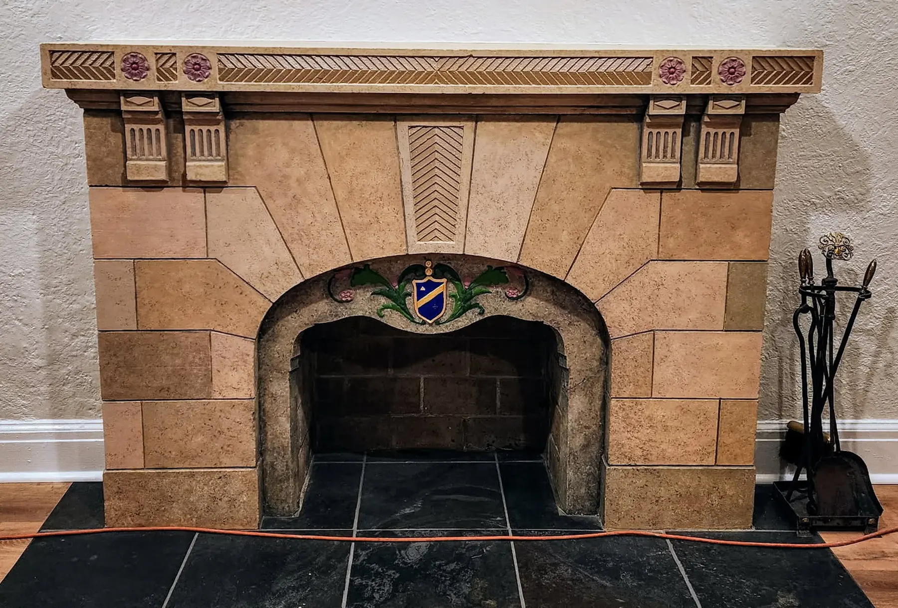The same fireplace after: painted stone blocks and a crest over the arch