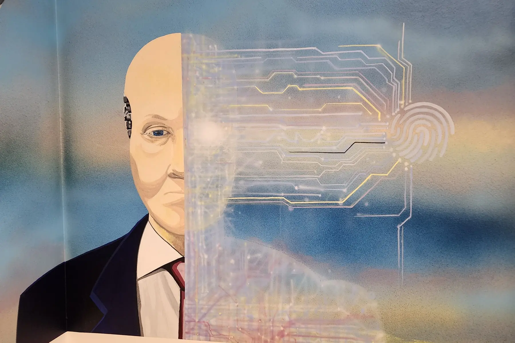 Mural of a man in a suit, half of his face drawn as a circuit board