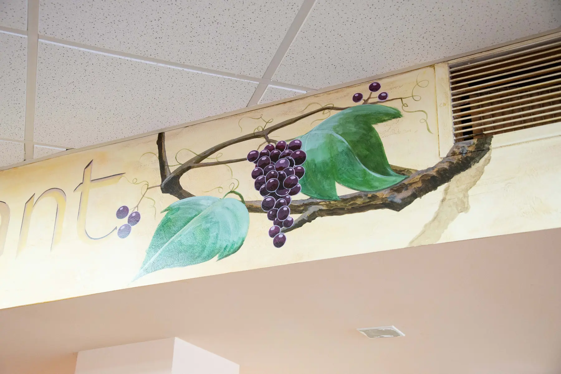 Painted grape vine with leaves along a soffit